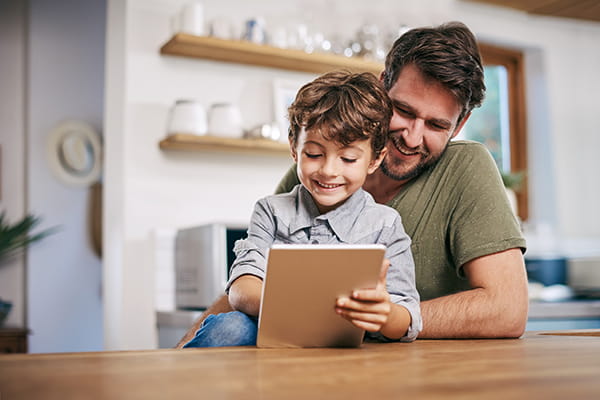Young boy with dad looking at tablet