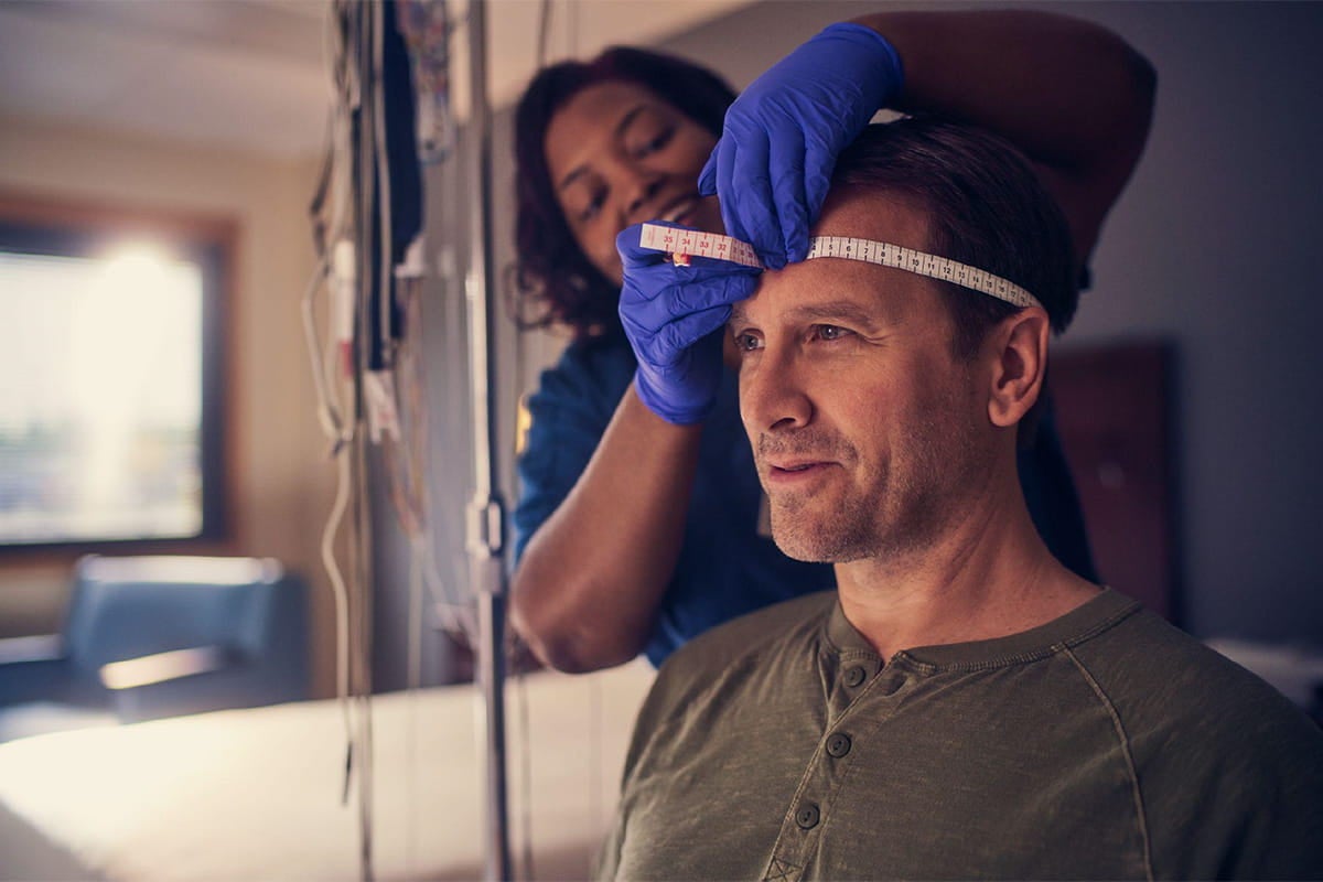 Care team member measures a patient’s head during a sleep lab visit