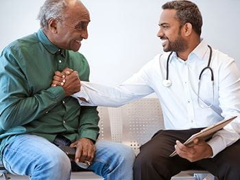 A doctor shakes hands with his patient.