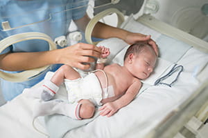 Newborn baby sleeping in an incubator.