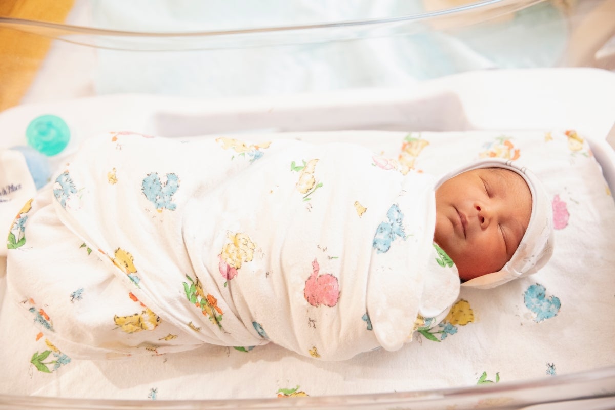 baby sleeping on back swaddled in blanket