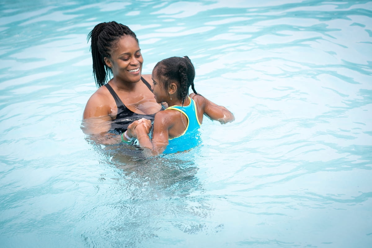 woman and little girl swimming in pool