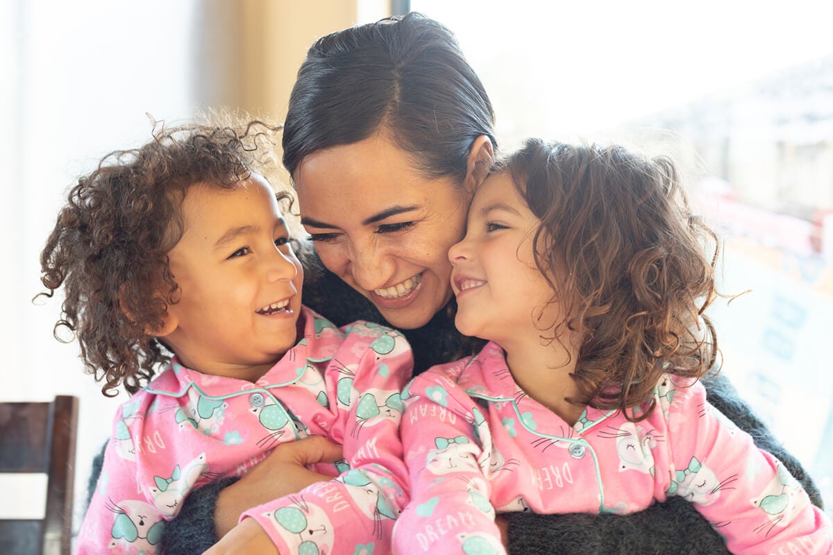 Mom laughing with two daughters.