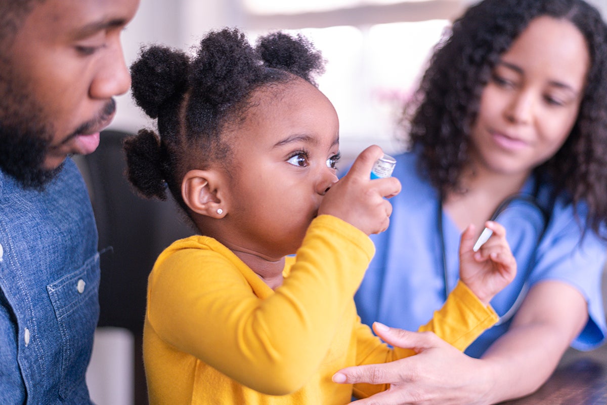 A girl with asthma using an inhaler.