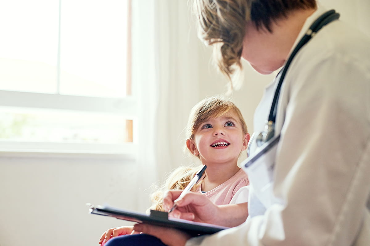 A female doctor talking with a child.