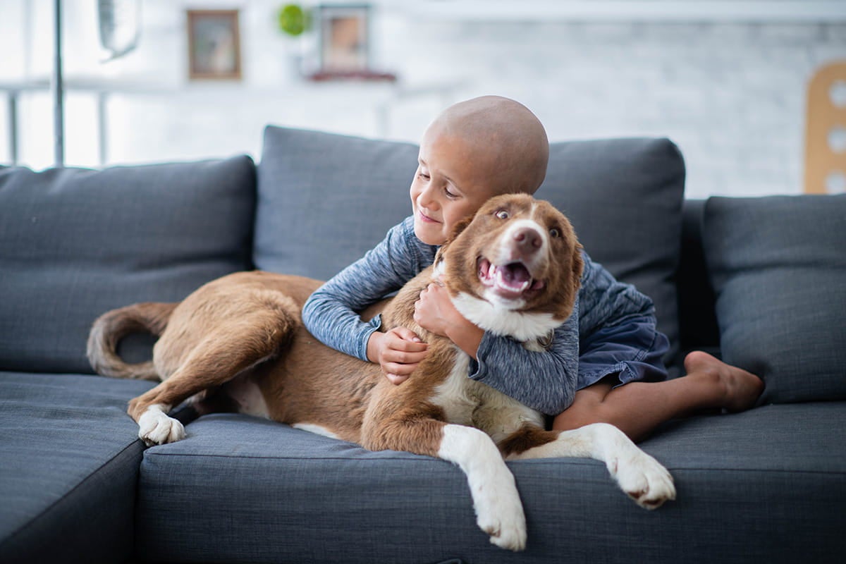 Child hugging a dog.