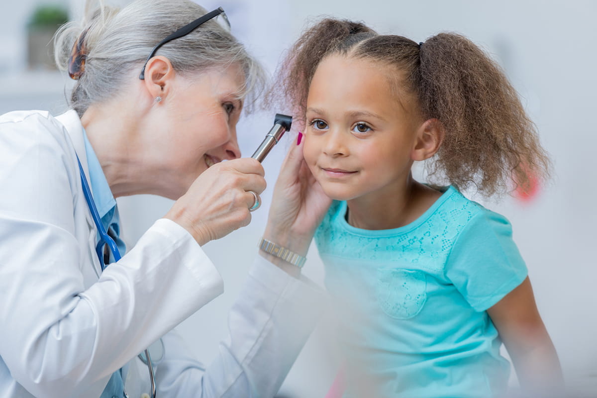 ENT doctor at Studer Family Children’s Hospital in Pensacola, Florida, looking in a child's ear.