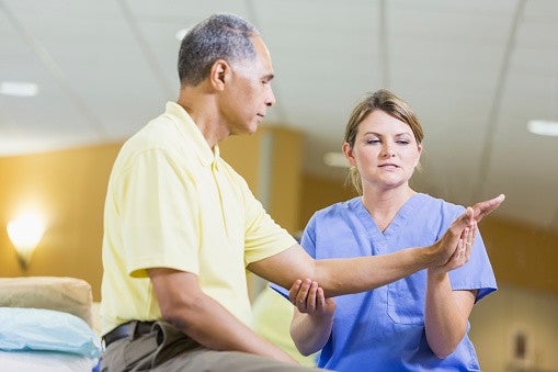 female provider delivering physical therapy to male patient