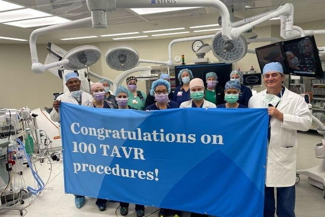 Ascension Providence Surgeons hold banner congratulating 100 TAVR procedures