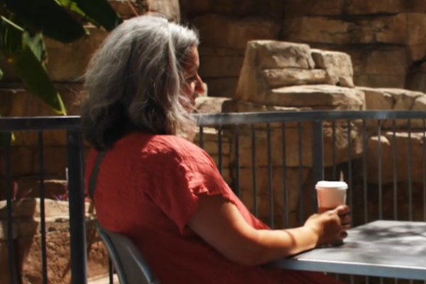 Becky sitting at Dell Childrens Medical center drinking a cup of coffee
