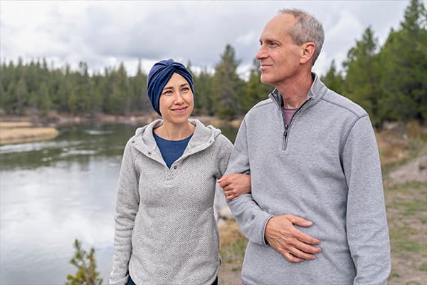 Woman and man walking by a lake.