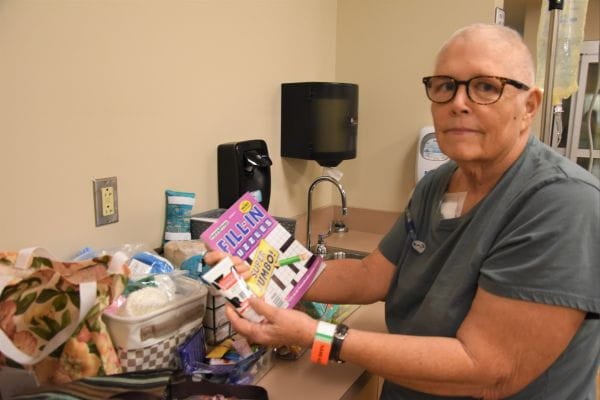 A cancer patient at Ascension Sacred Heart Pensacola poses with a gift basket sent by a member of the Pensacola community through the Amazon Wish List program.