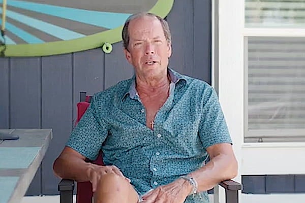 Greg R sitting in a chair on the beach