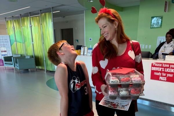 Zeph, now a healthy ten-year-old, and his mom, Liz, visit Studer Family Children's Hospital ER to deliver Valentine's treats and show their heartfelt appreciation for the specialized care Zeph received. The staff welcomes them with smiles reflecting the strong bond they have formed through their shared experiences.