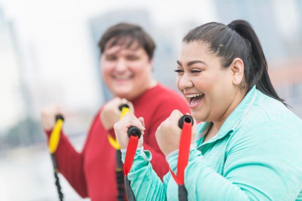 stock photo of smiling woman exercising with weight bands