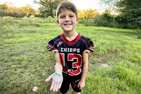 Russell shows bracelet he makes to inspire others