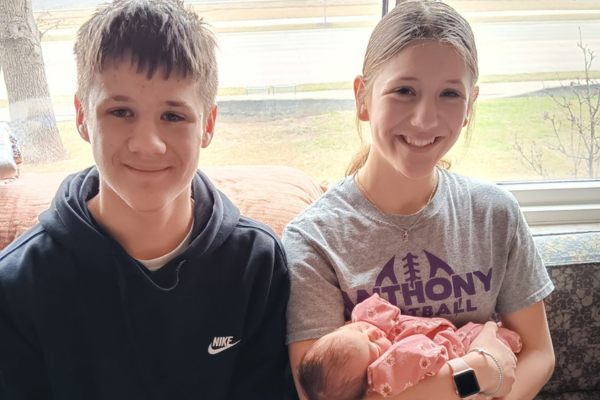 Grace's son and daughter holding newborn sibling
