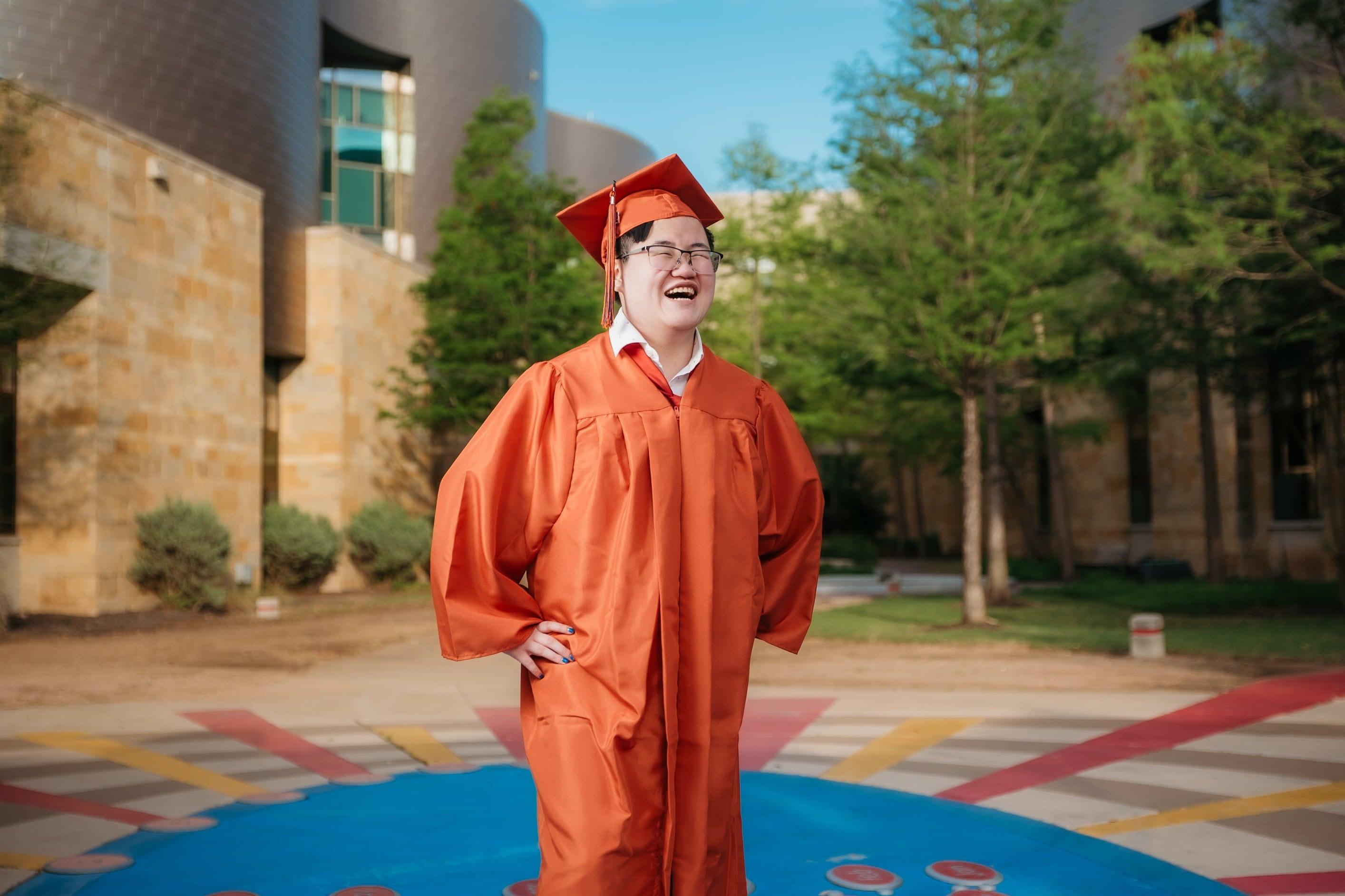 Ryen Jennings in dark orange graduation cap and gown