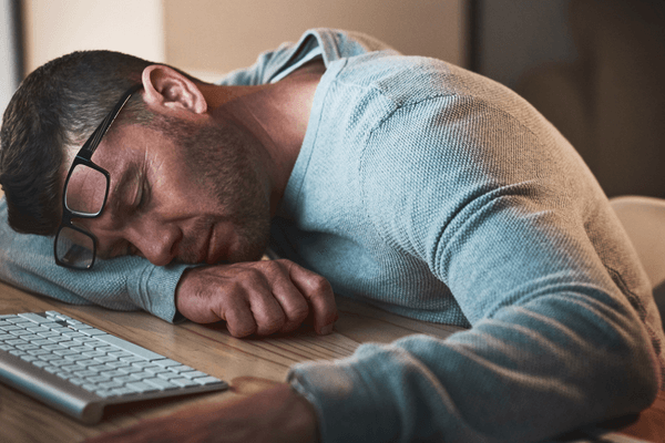 A man sleeping at his desk.
