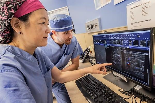 Dr. Christina Kim and Dr. Ian Sando collaborating on care while looking at a patient’s imaging.
