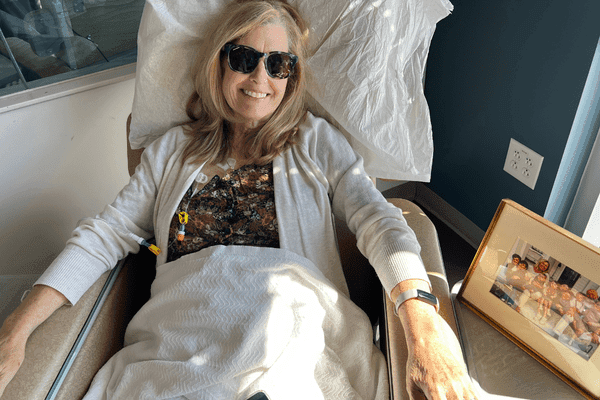 Laura smiling in sunglasses during a "Chemo Beach" treatment session.