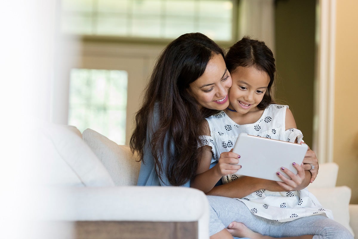 Mother and daughter looking at a tablet.